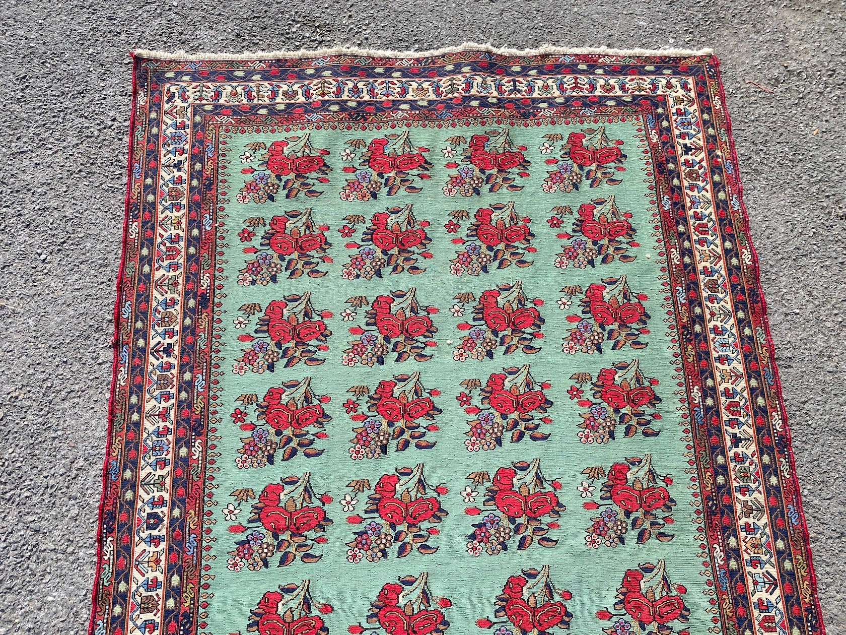 A Kirman Shah rug woven with floral bunches on a green ground within a conforming multi border 184cm X 120cm
